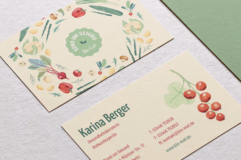 Two business cards on a white surface featuring botanical illustrations and contact information for health consultant Karina Berger.