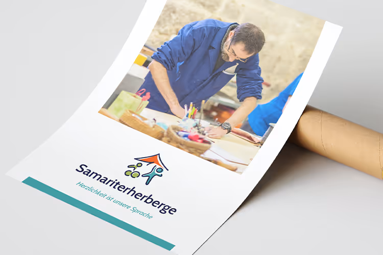 Brochure with image of a man in a blue jacket working at a table, featuring the Samariterherberge logo and the slogan 'Herzlichkeit ist unsere Sprache.'