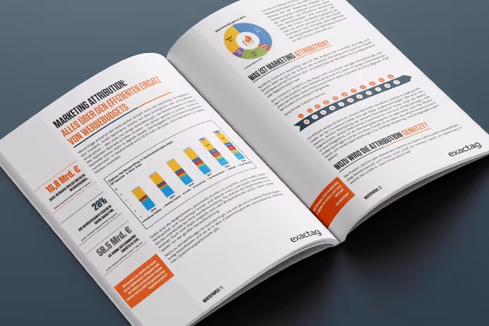 Open book displaying marketing attribution content with charts and highlighted text in German on a gray surface.