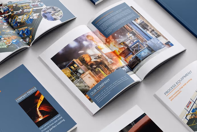 Open company brochure showing industrial manufacturing process with molten metal and equipment images, surrounded by other brochures.