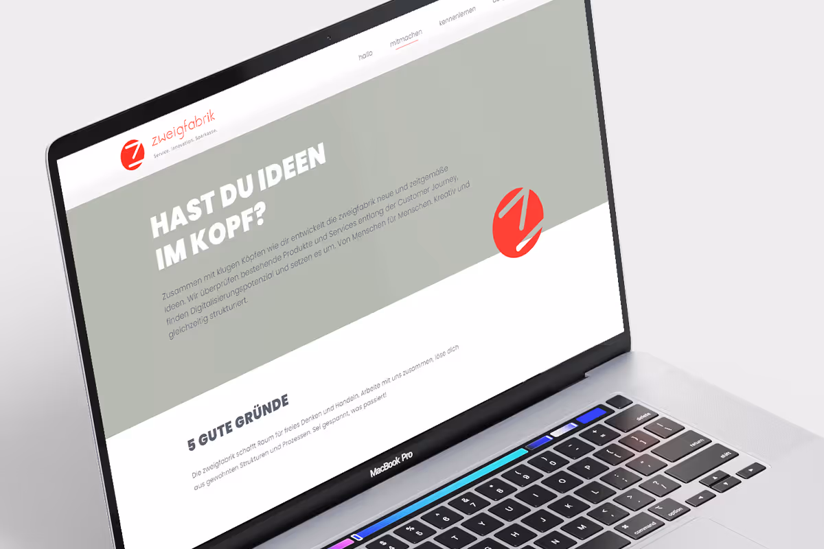 MacBook Pro displaying a webpage in German with the headline 'Hast du Ideen im Kopf?' and sections about idea development and reasons to collaborate, featuring a red logo of Zweigfabrik.