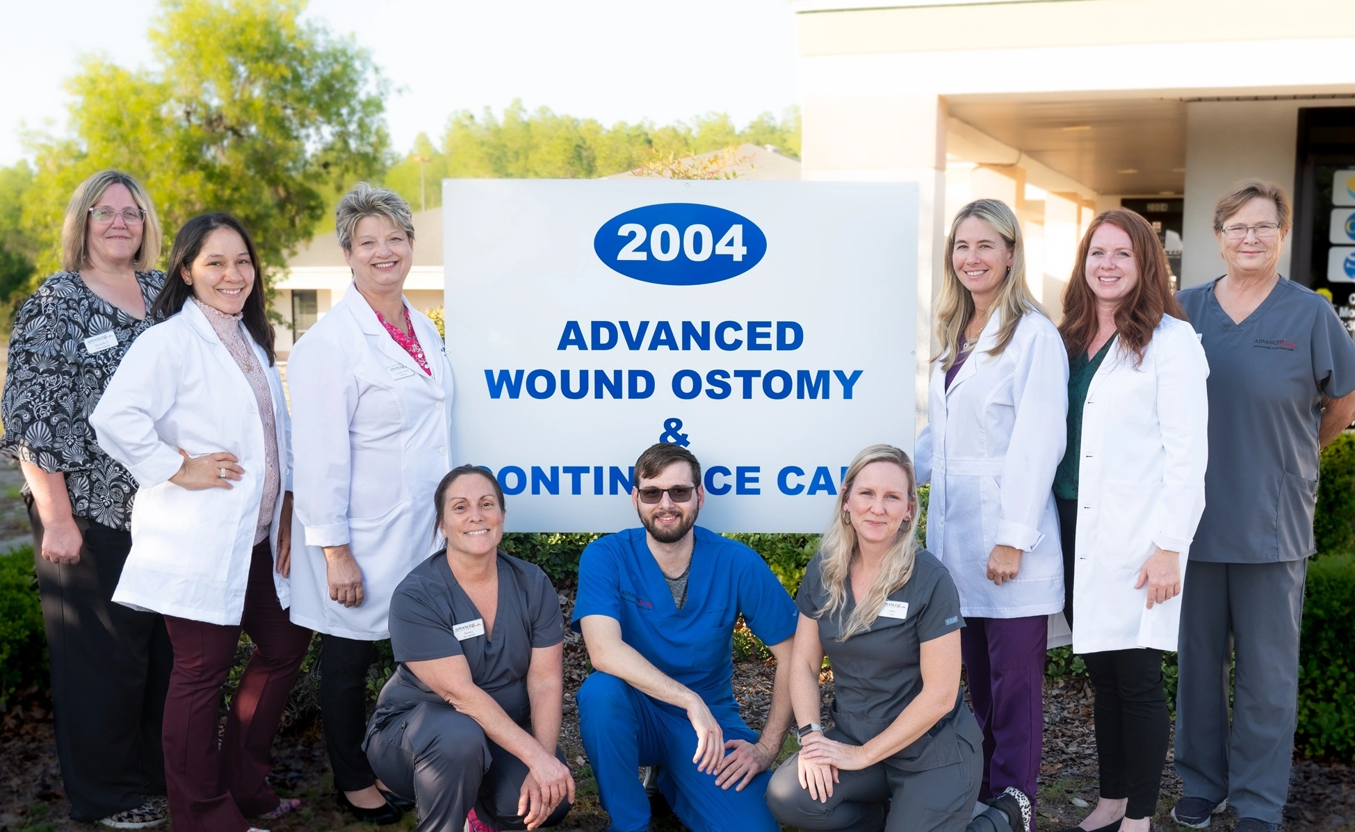 A group of doctors posing in front of a sign.