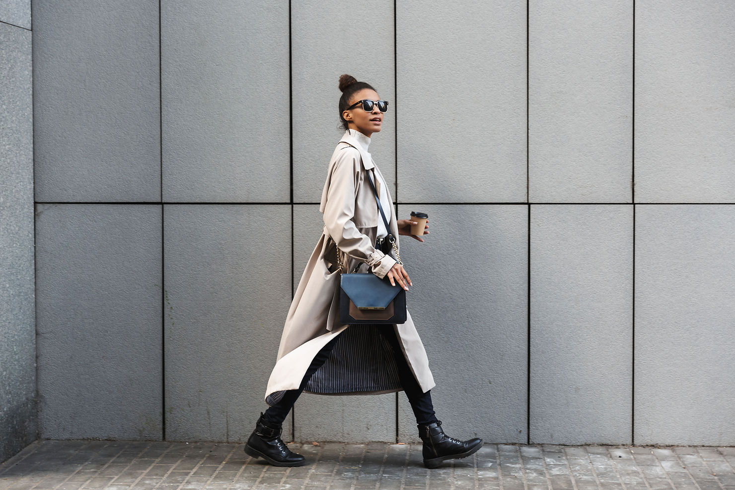 Woman in coat with coffee walking