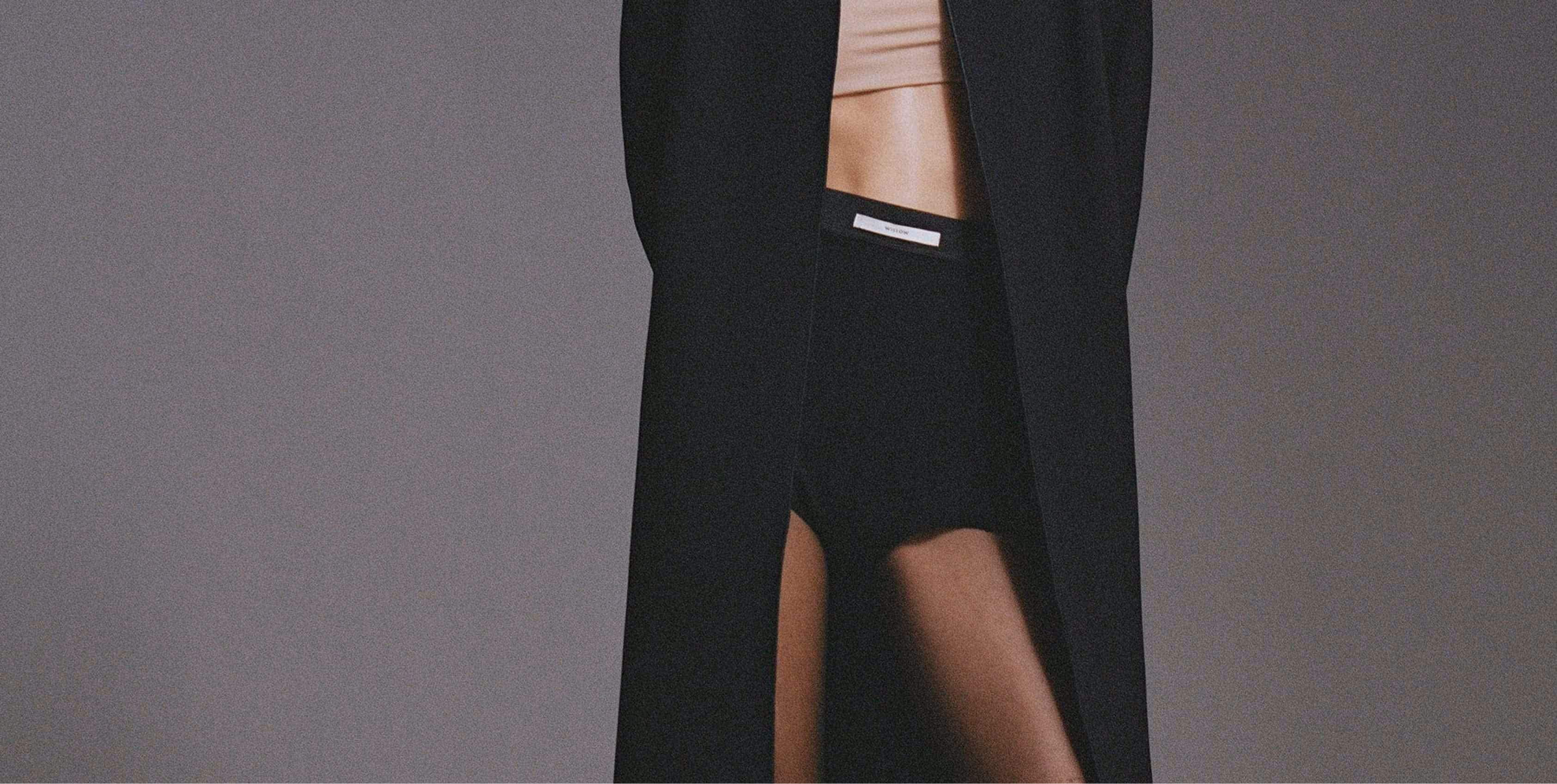 a woman wearing a black coat and underwear