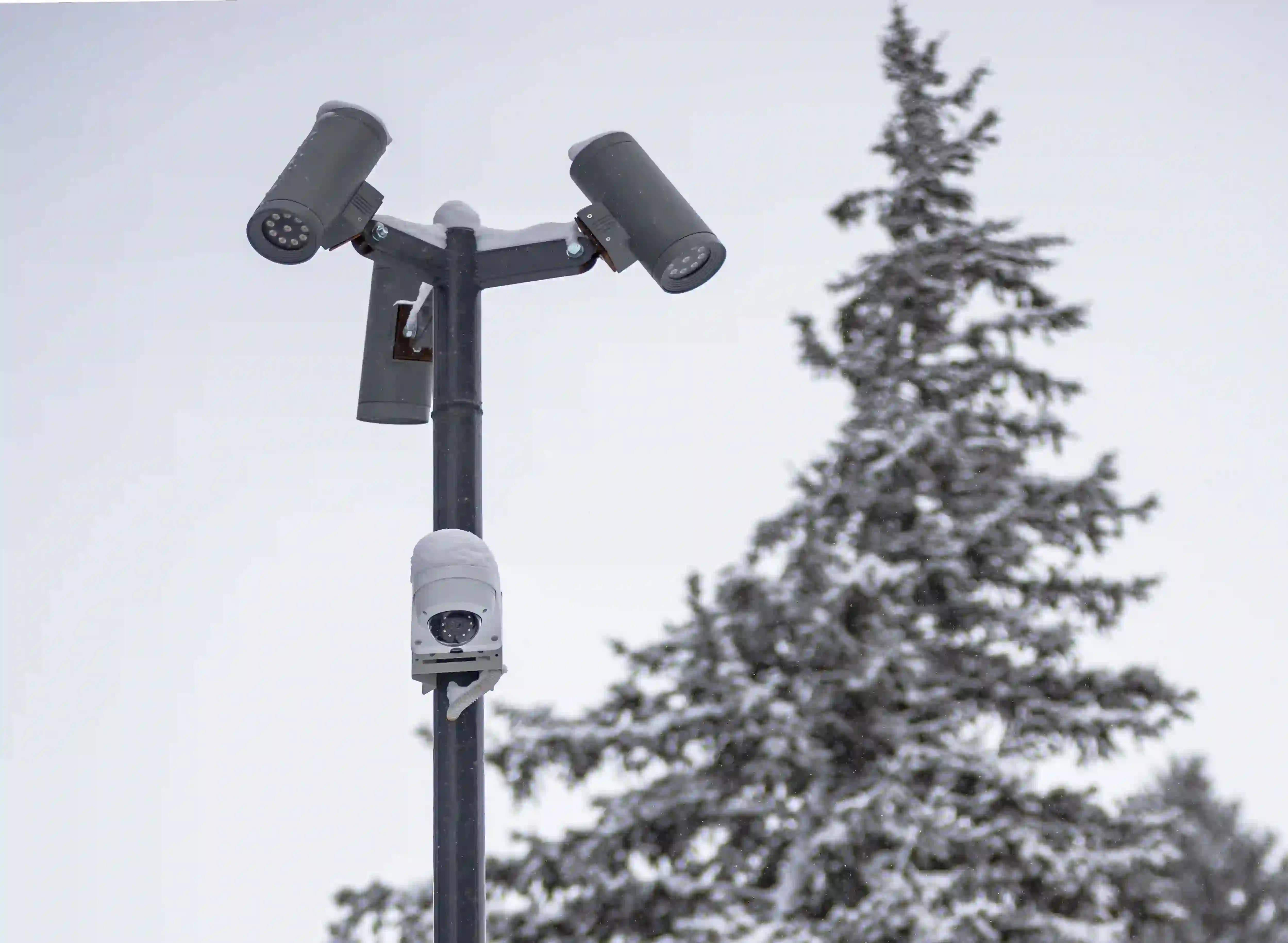 Caméras de surveillance installées sur un poteau en cas de neige hivernale.