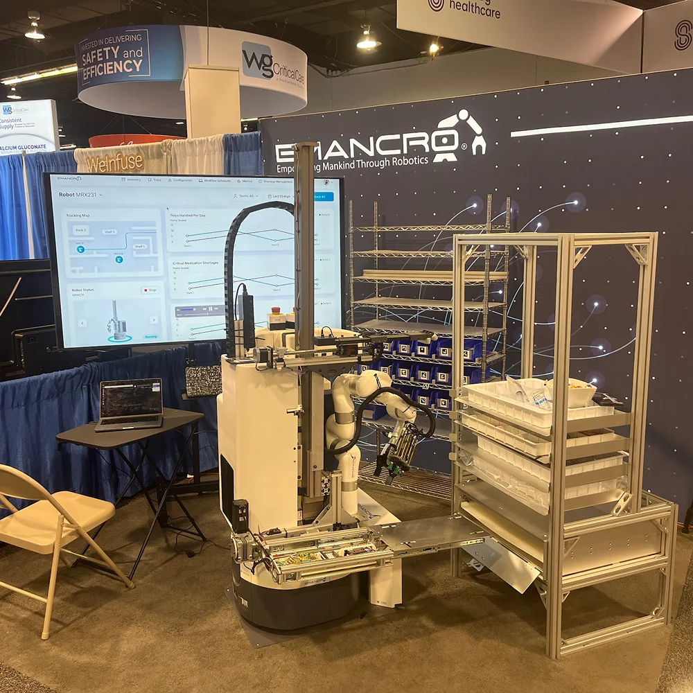 Emancro robot with a manipulator automating logistics at a booth with screens and storage racks.