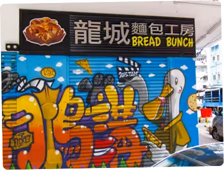 Colorful mural outside Bread Bunch bakery featuring cartoon-style illustrations of bread, pastries, and food characters with Chinese and English signage