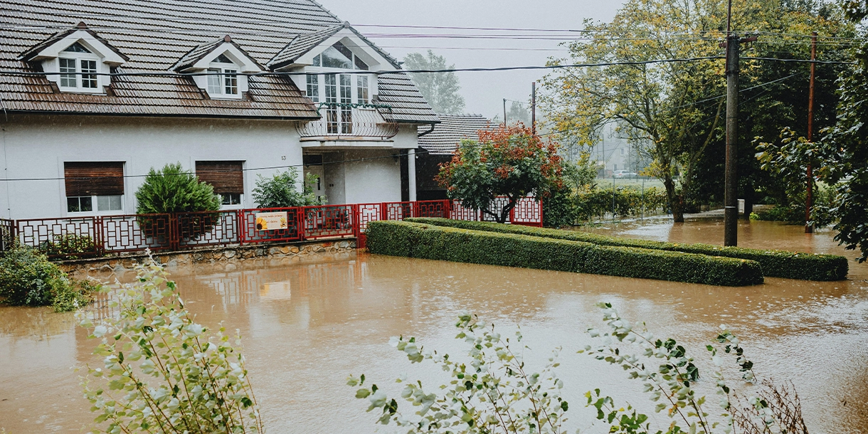 View of a house and the front lawn, all flooded with water