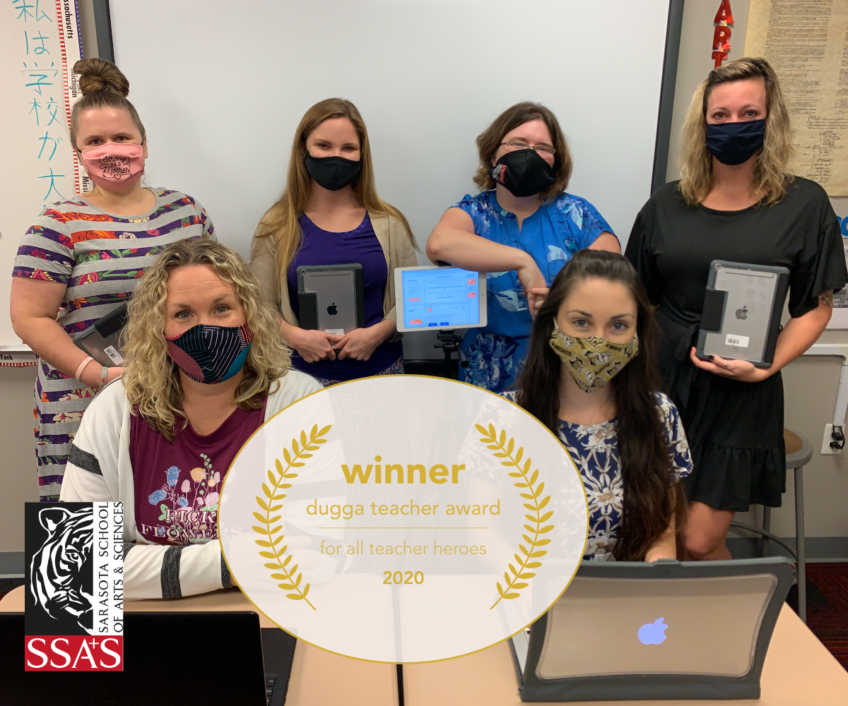 Six masked women in a classroom, some holding tablets. "Dugga Teacher Award" & school logo overlay.