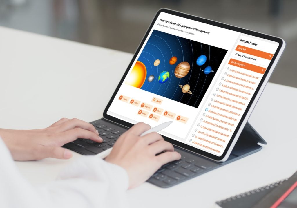 Hands on a tablet keyboard. Screen shows an online test with a solar system quiz and quick navigation pane.