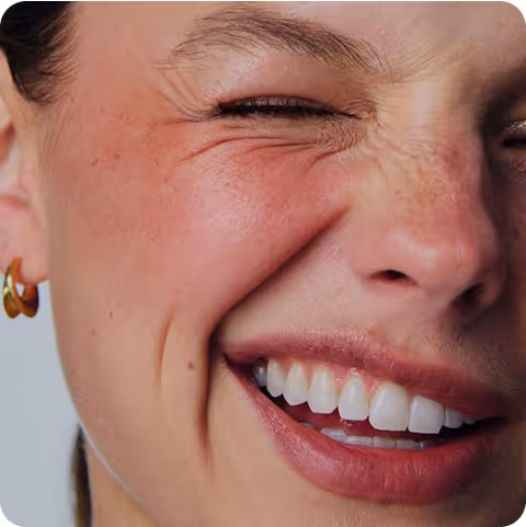 Gros plan sur un sourire féminin, peau lumineuse et expression joyeuse