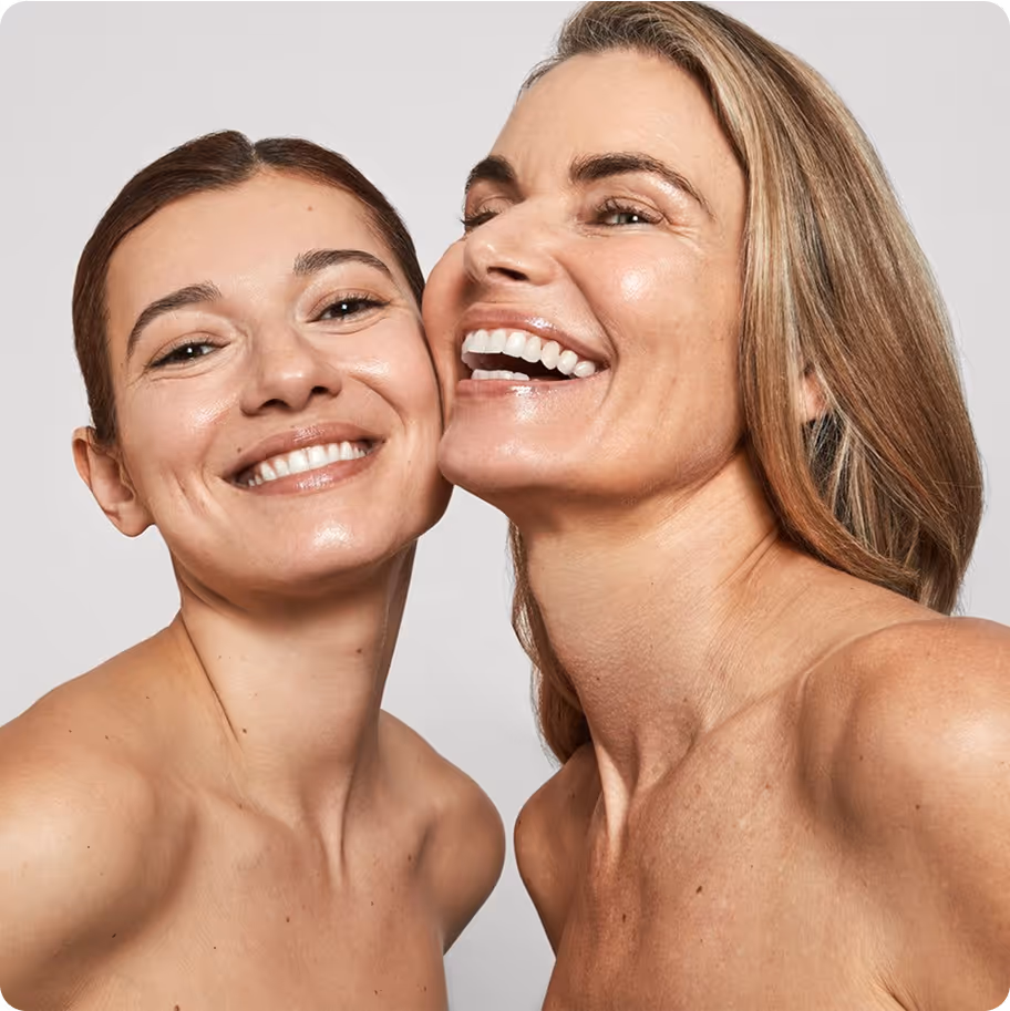Deux femmes souriantes, peau naturelle et éclatante, photographiées sur fond neutre