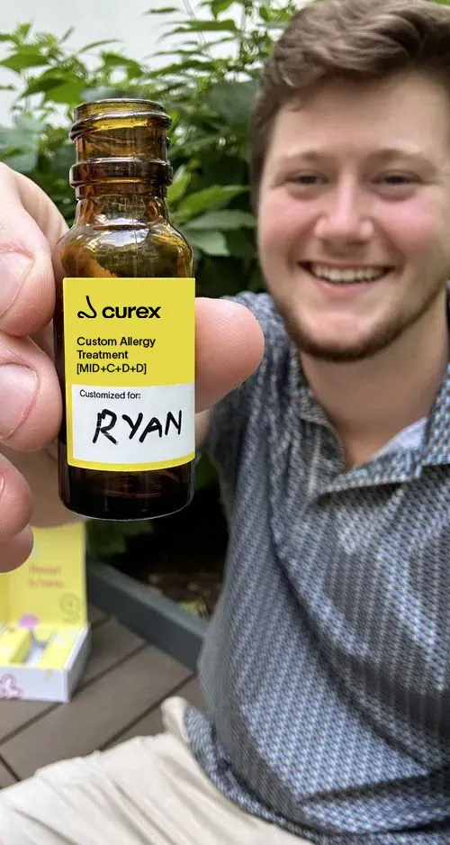 curex user showing allergy drops vial while smiling