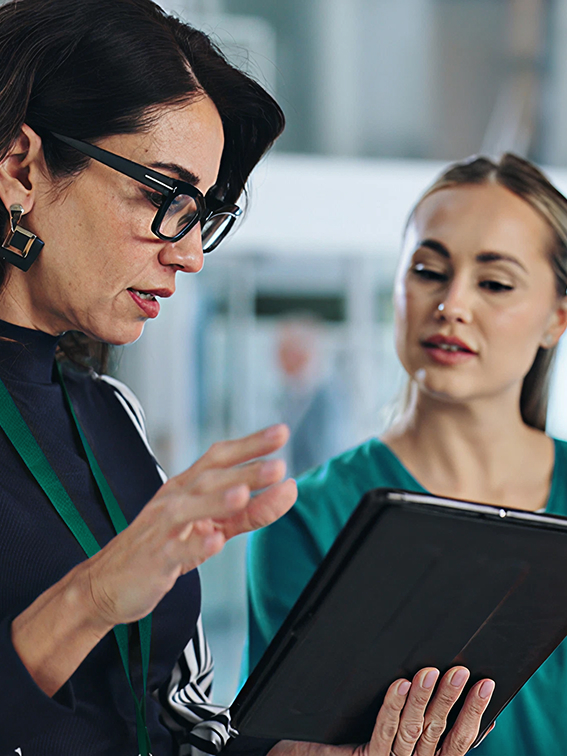 Female consultant holding iPad and discussing options with a team member