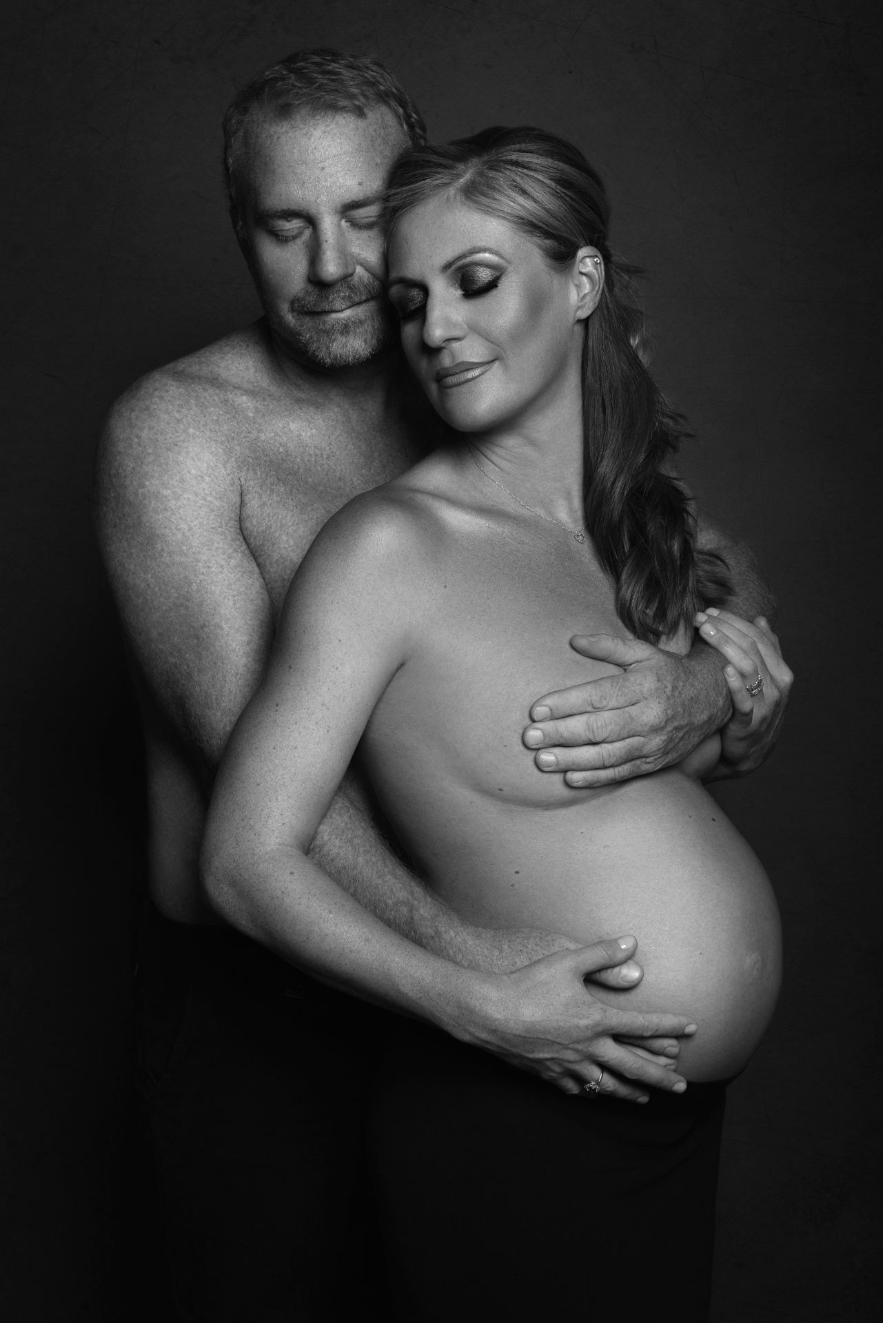 Foto di coppia maternità in bianco e nero a Bologna con Claudia Spaziani: partner abbraccia donna incinta, posa intima e affettuosa.