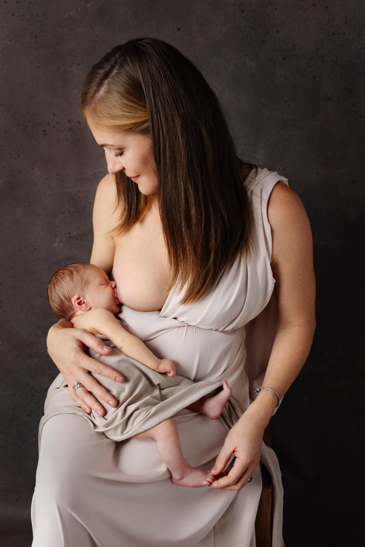 Ritratto di madre che allatta neonato maschio, realizzato da Claudia Spaziani fotografa a Bologna. Immagine elegante e naturale che esalta maternità e cura.