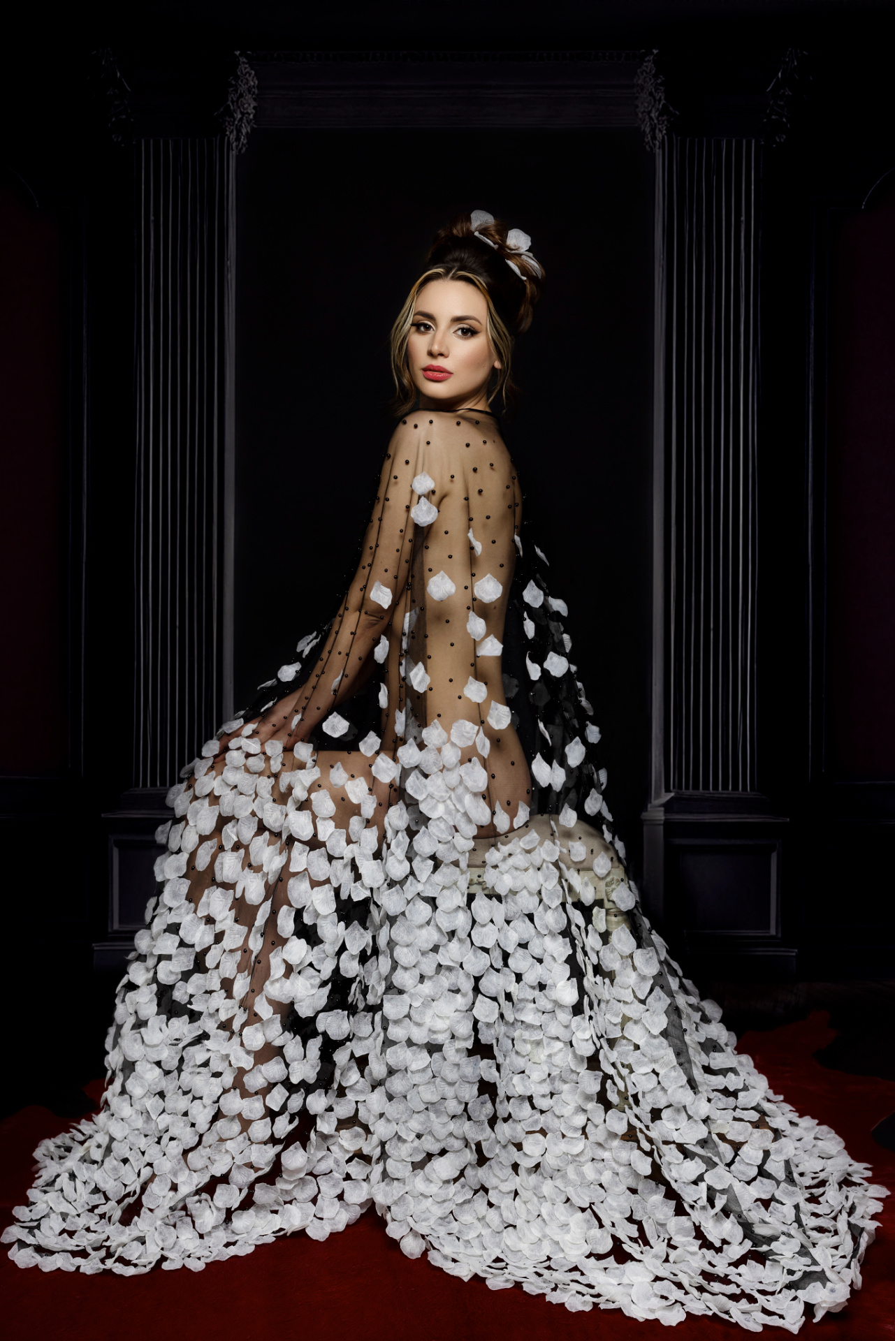 Ritratto fine art realizzato da Claudia Spaziani vicino a Bologna; abito nero trasparente con applicazioni bianche, ambientazione architettonica classica e composizione elegante.