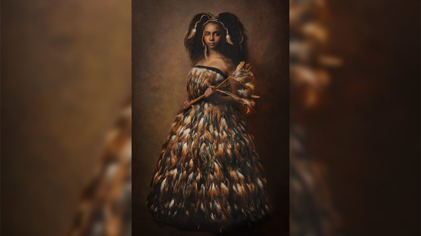 Ritratto artistico di ragazza con abito di piume dorate su sfondo scuro – fotografia fine art bambini e ragazzi di Claudia Spaziani, Bologna