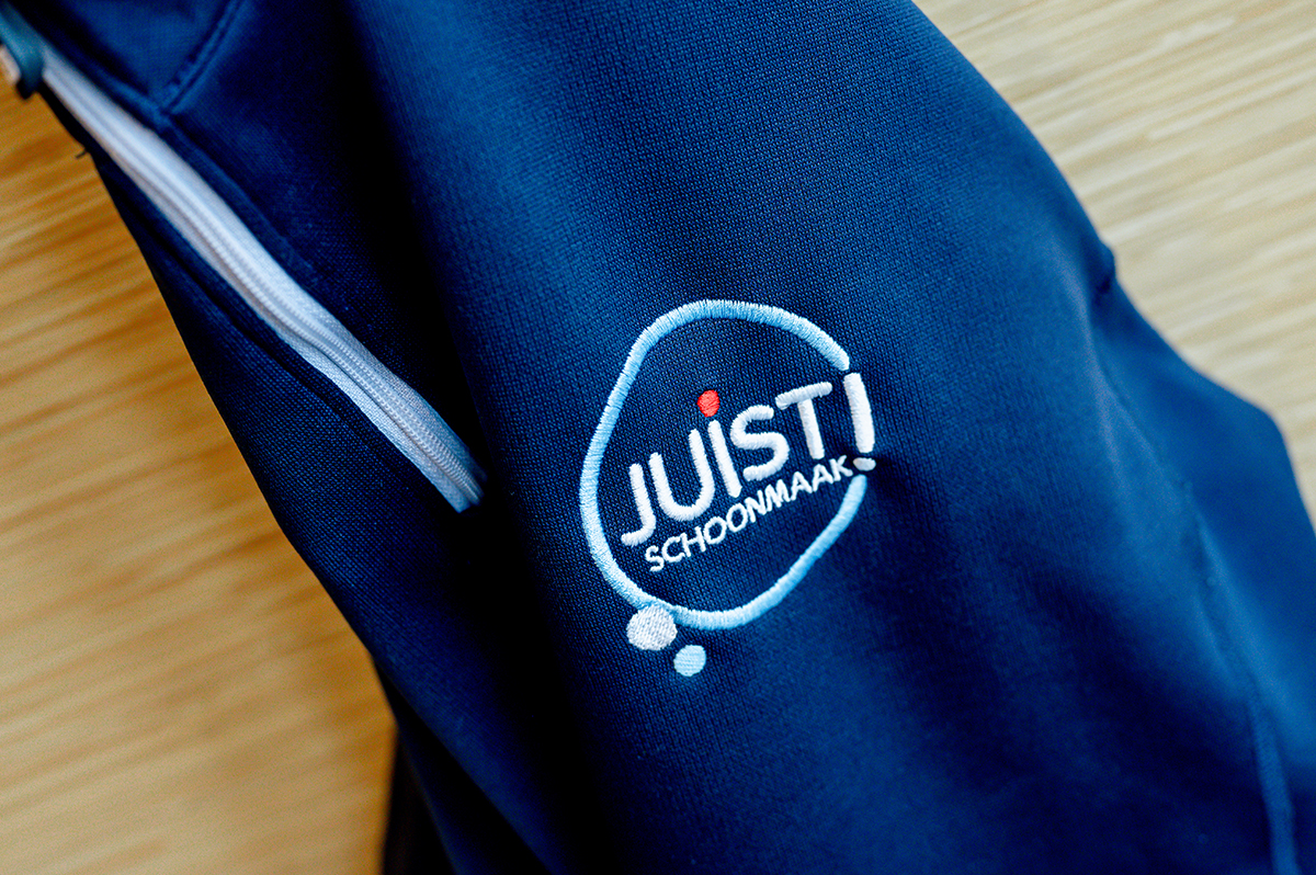Juist schoonmaak vest van dichtbij met het logo er op.