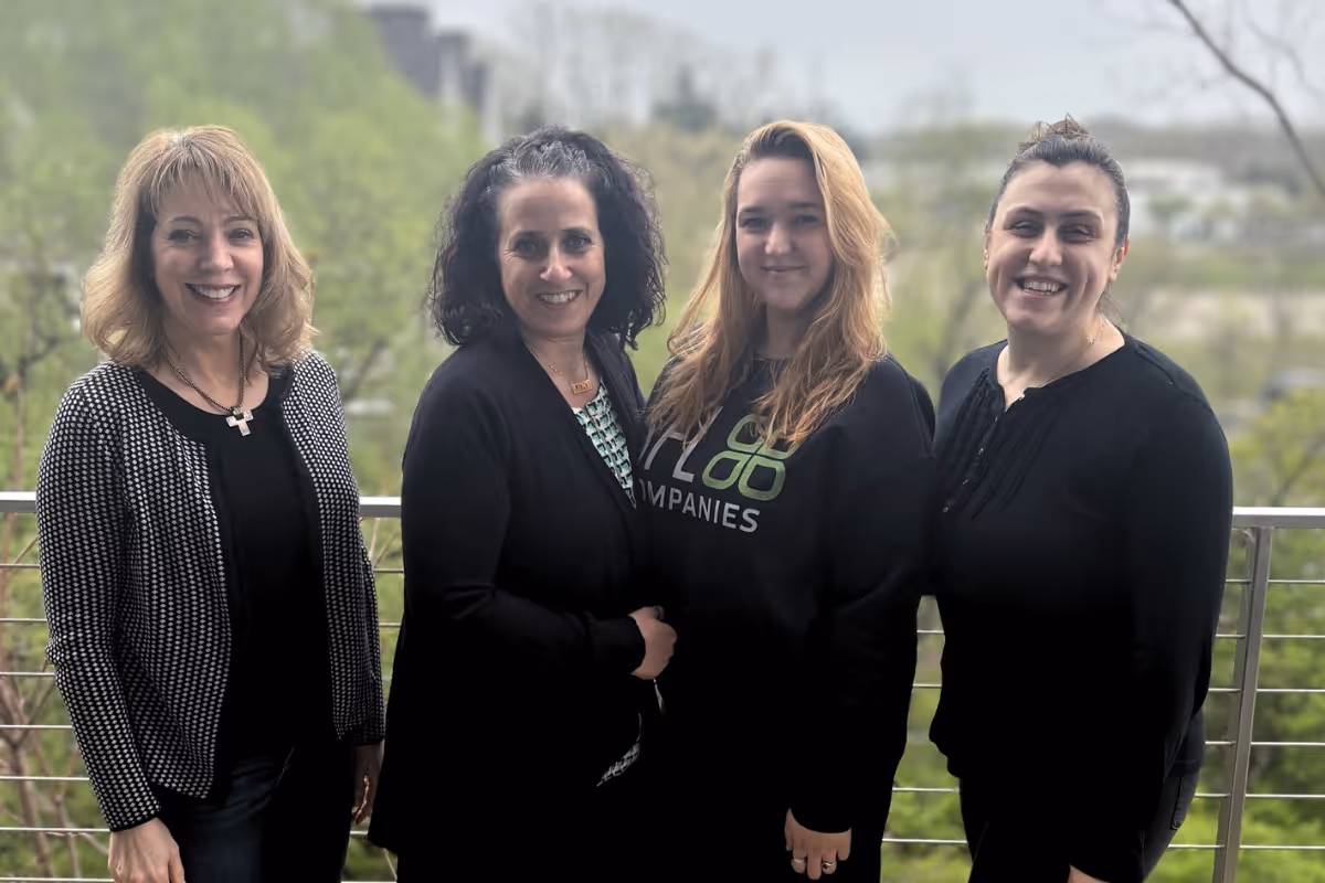 SFL Companies team of four women smiling together outdoors