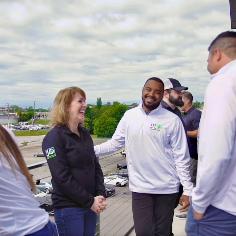 SFL Companies employees smiling and shaking hands on rooftop parking lot