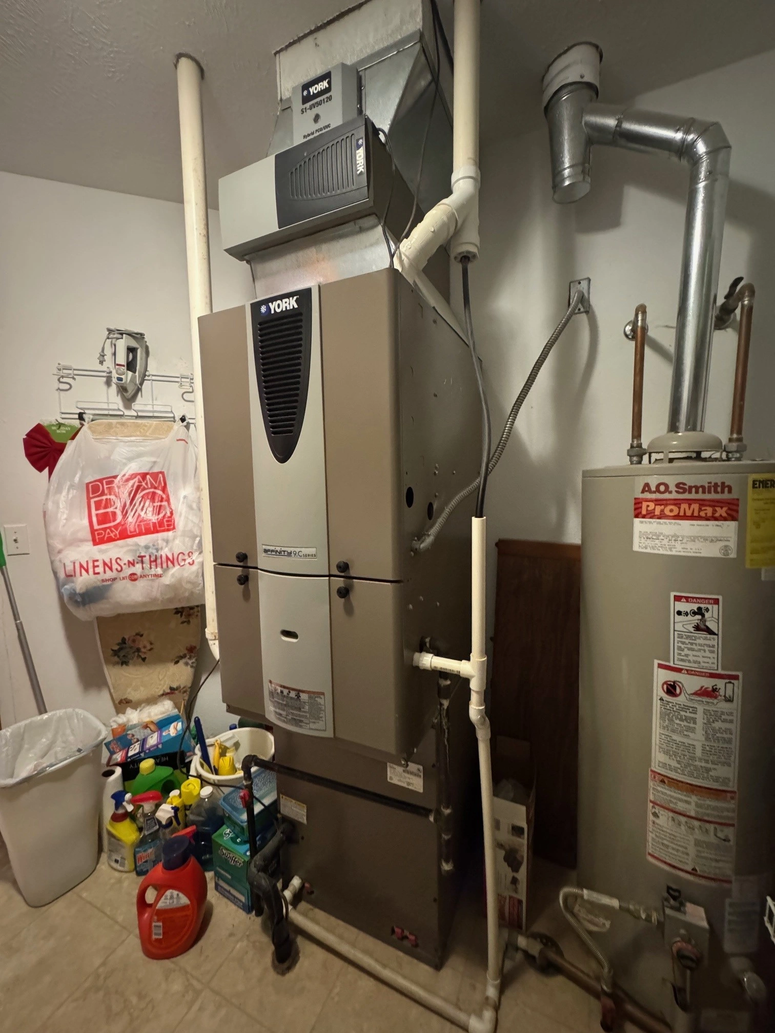 Basement utility room with a large York HVAC system and an A.O. Smith ProMax water heater. 