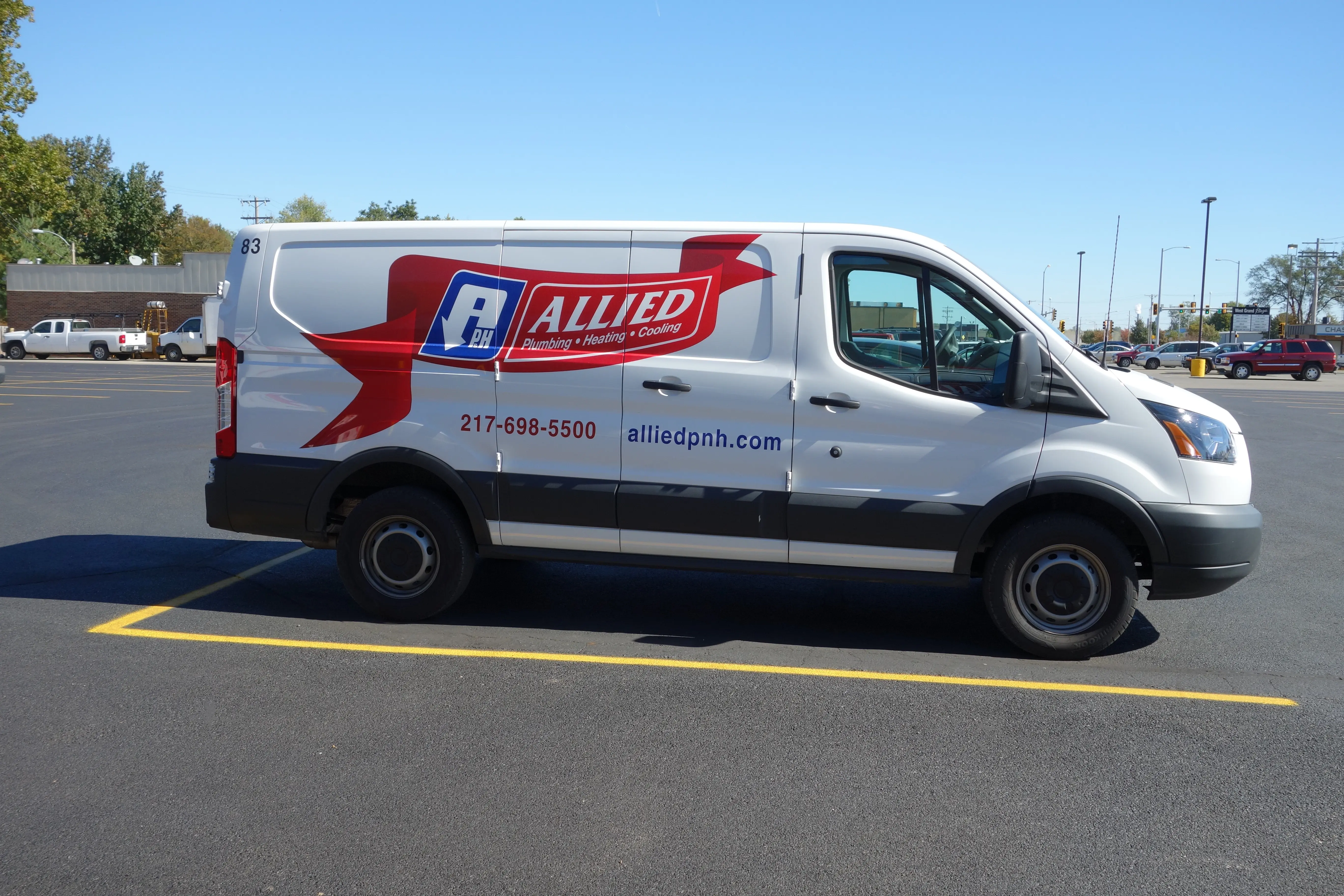 White van in a parking lot with "Allied Plumbing, Heating, Cooling" logo and contact info. 