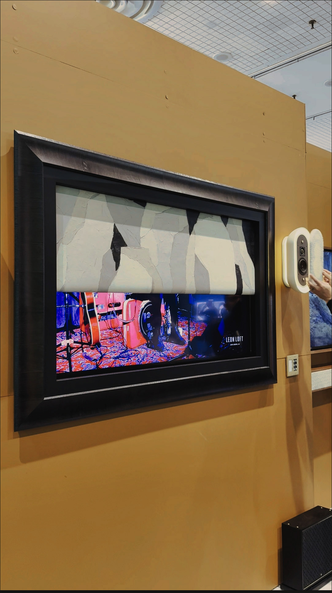 A black frame with a rolling art screen covering half a TV.