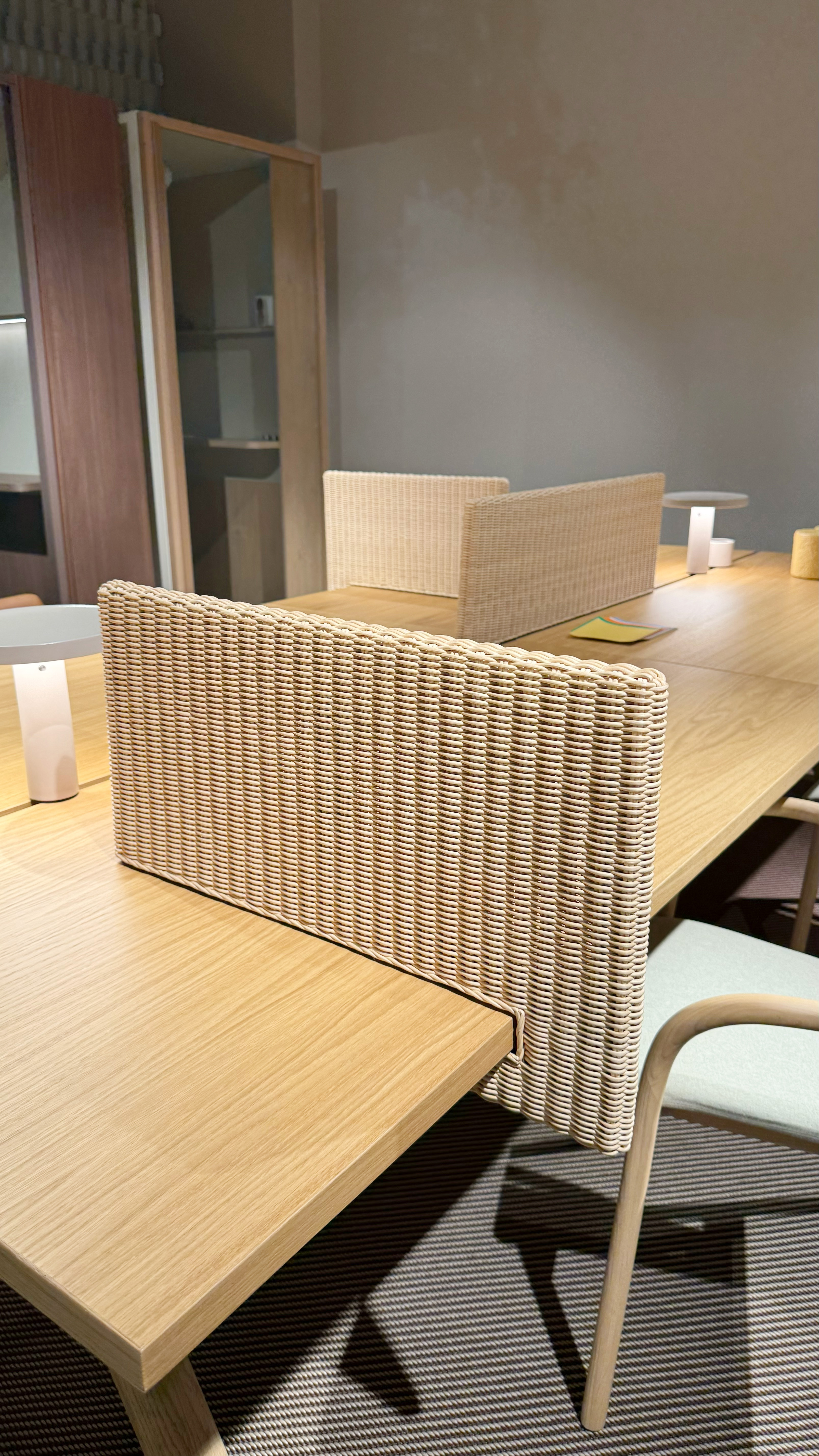 Wicker sheet attached to a desk to provide privacy.