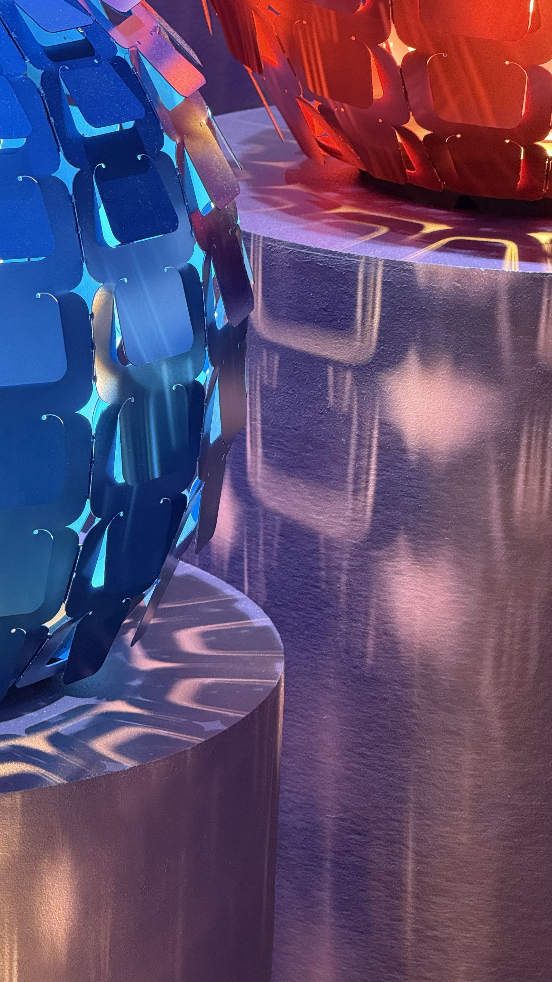 Blue and red tabbed lights that cast a unique shadow onto a purple wall.