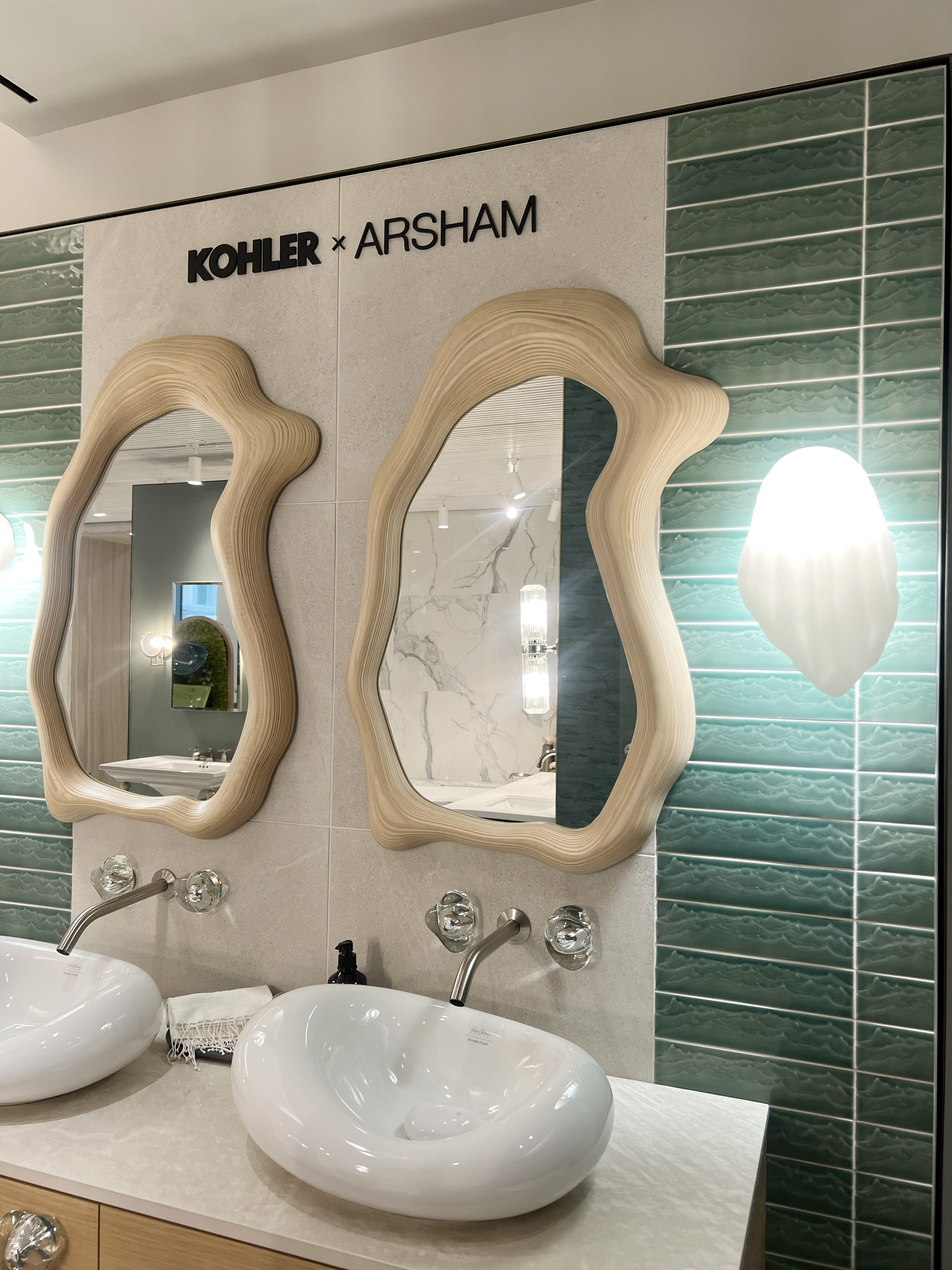 Organic shaped mirror with a wooden rim. Sat above a large bean shaped sink.