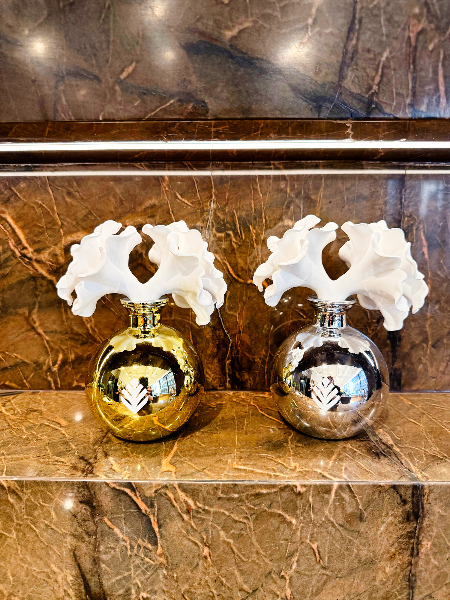 Gold and silver spherical diffusers with white ceramic flowers coming out of the top.