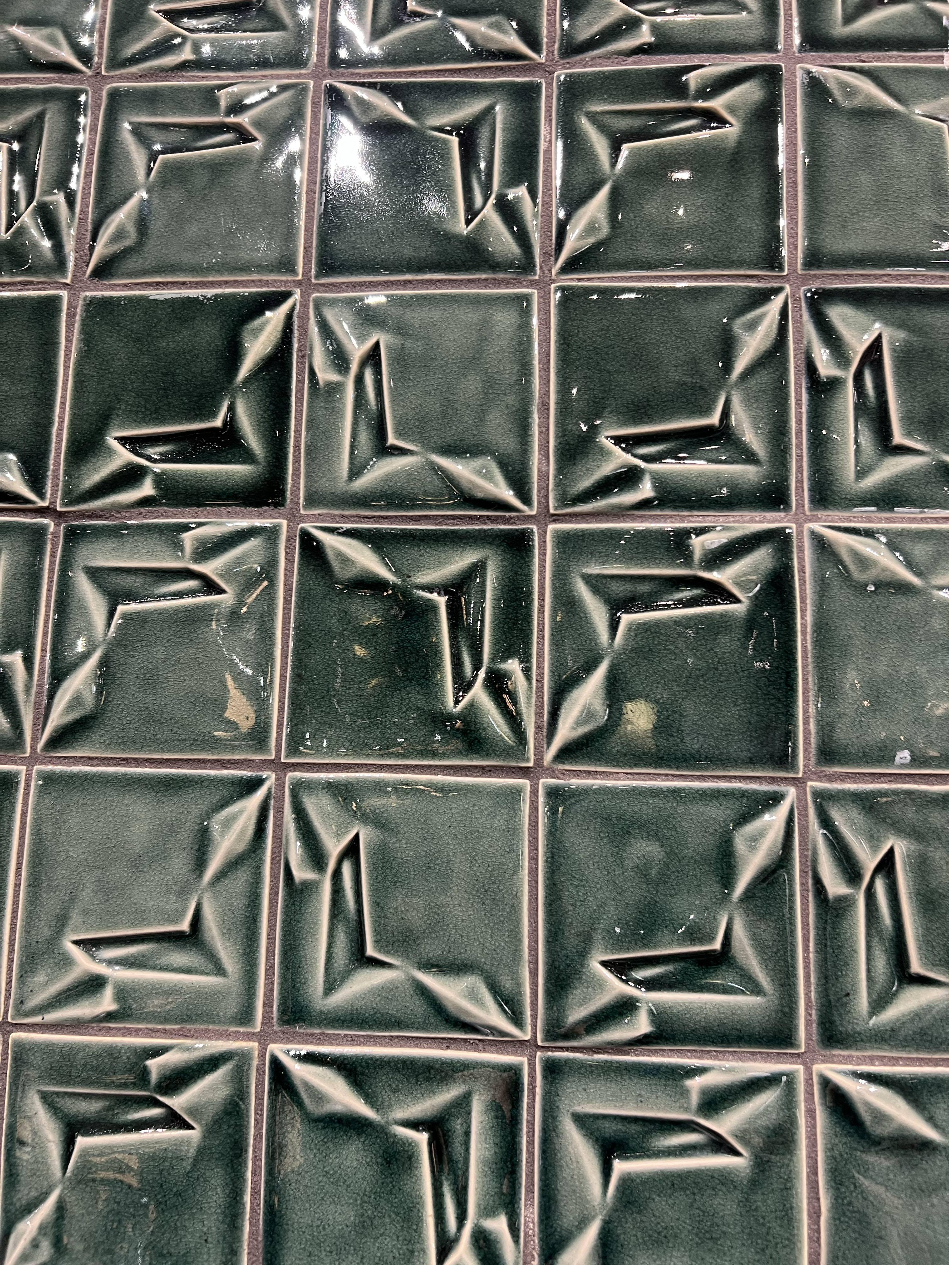 Green textured decorative tile arranged in a way where the texture creates a pattern