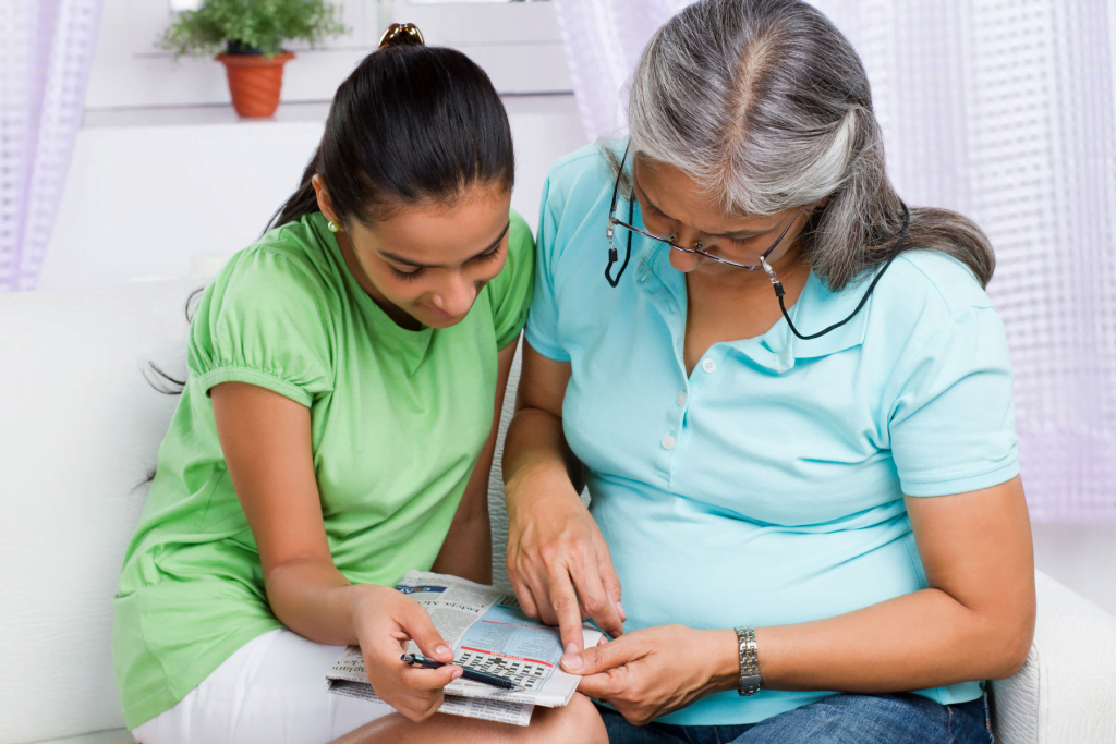 An older woman and teenagers solving the crossword.