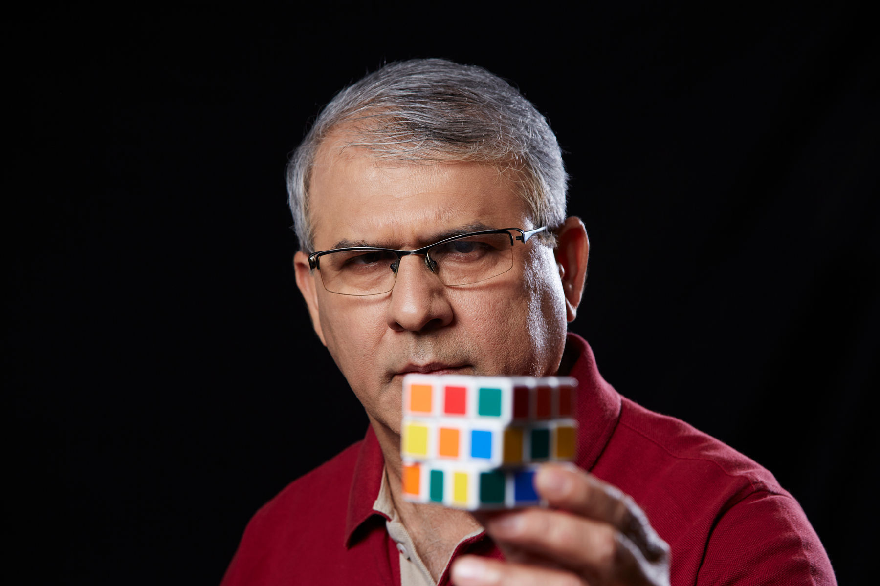 An older person showing a Rubik's Cube