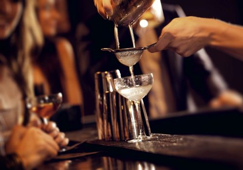 a person pouring a mixed drink