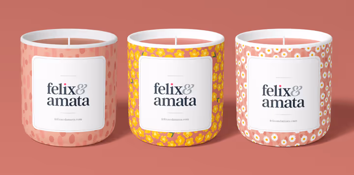Three candles with the Summer Lawn pattern collection as the label, each label features a pattern from the Sunrise colorway. White English daisies, yellow buttercups, and pink handrawn dots on peach pink backgrounds.