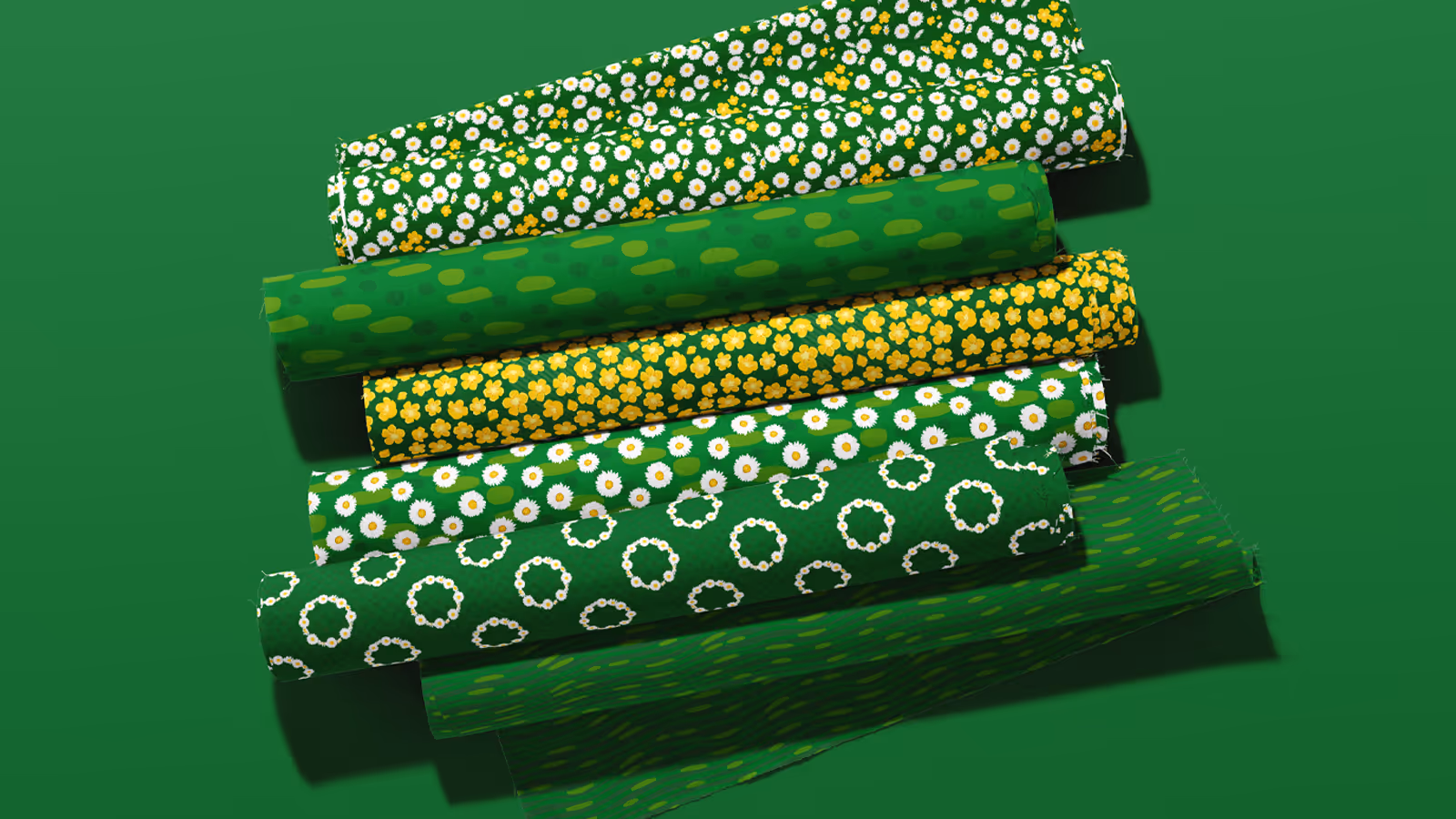Six rolls of green fabric in the Summer Lawn pattern collection in the Fresh Meadow green colorway. Patterns have English Daisy's and yellow Buttercups, along with hand-drawn dots and lines. 