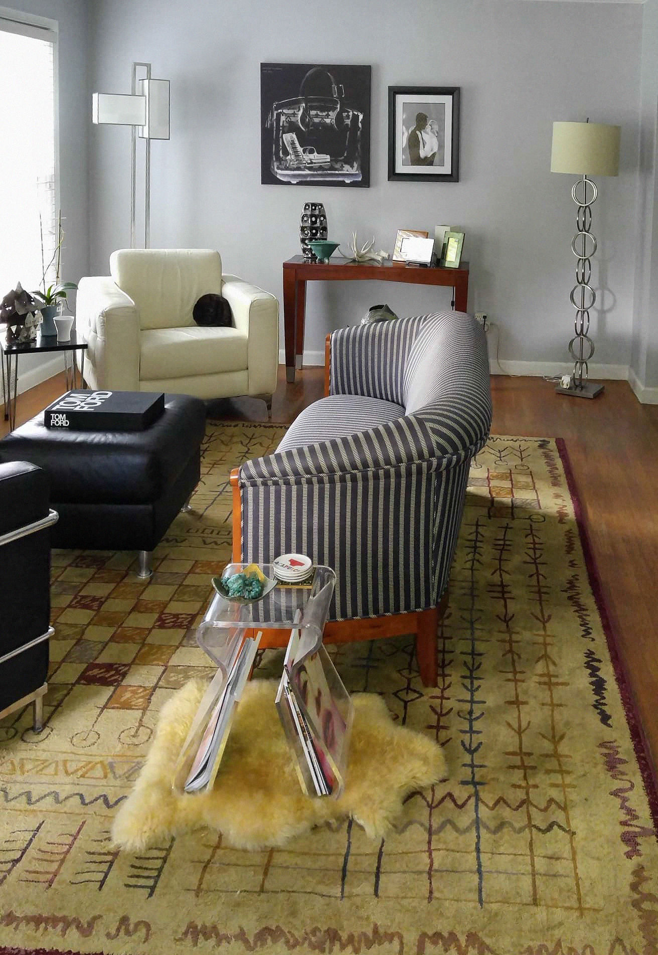 Living room before makeover with oversized patterned rug dominating the space