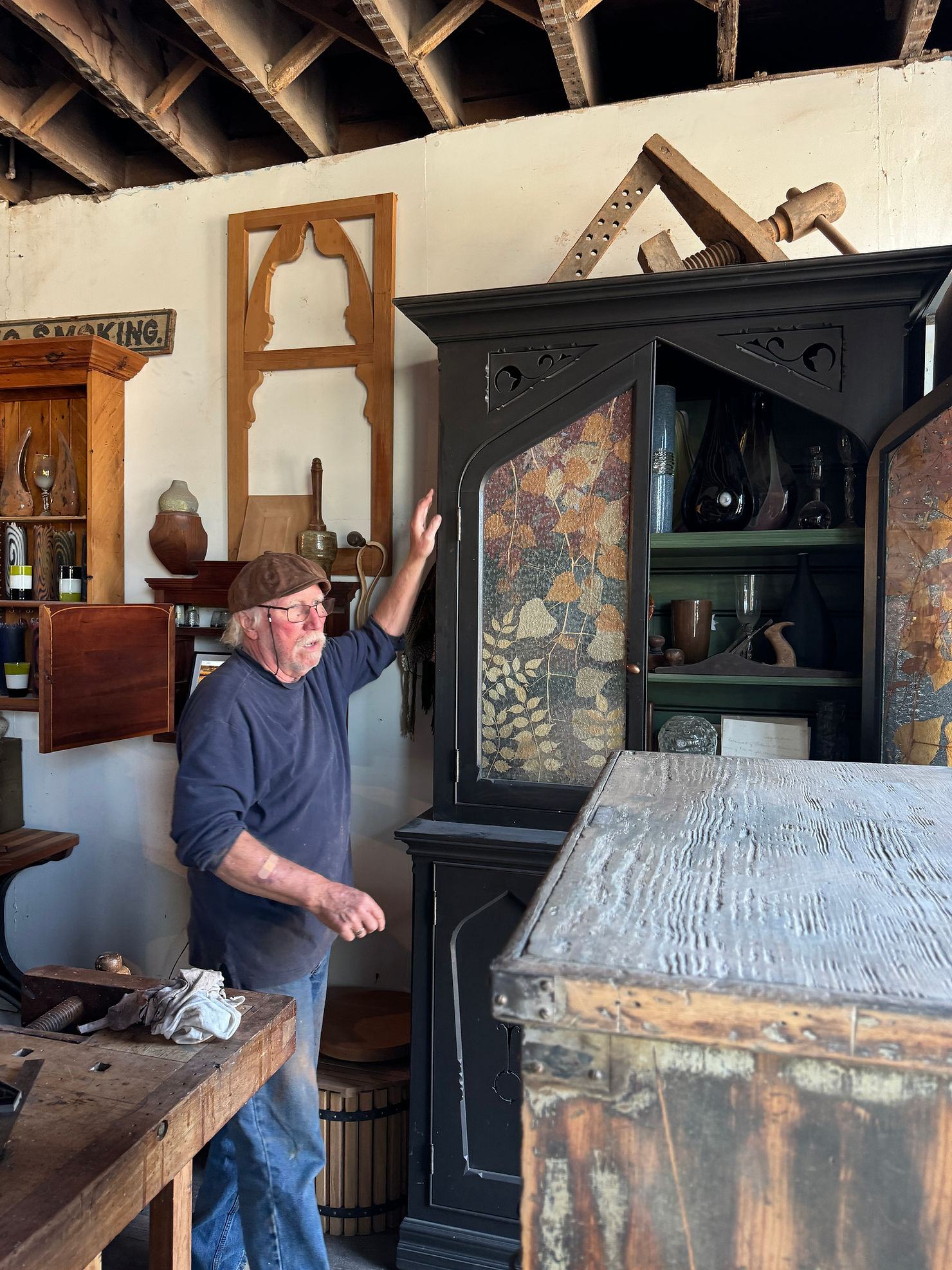 Craftsman shaping wood with traditional tools in a historic workshop setting