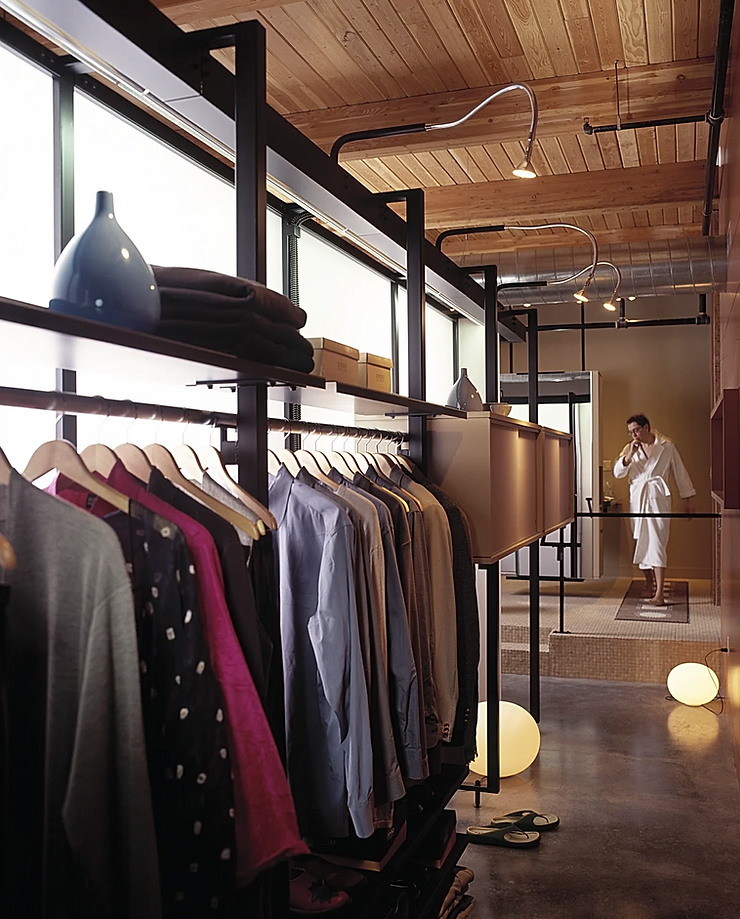 Modern open closet with shelving displaying clothing and accessories in a loft space