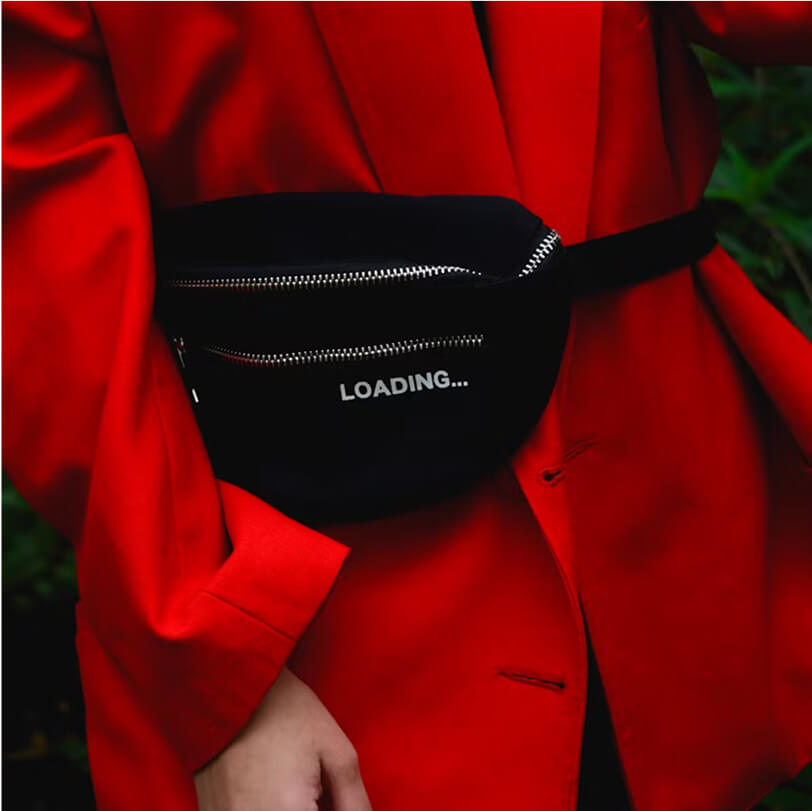 Person wearing a red jacket with a black waist bag that has a zipper and the word 'LOADING...' printed on it.