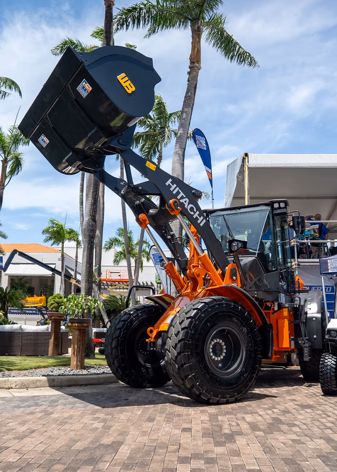 Hitachi ZX135US excavator with Puerto Rico Wire Group branding on display at AGC Puerto Rico 2025 trade show