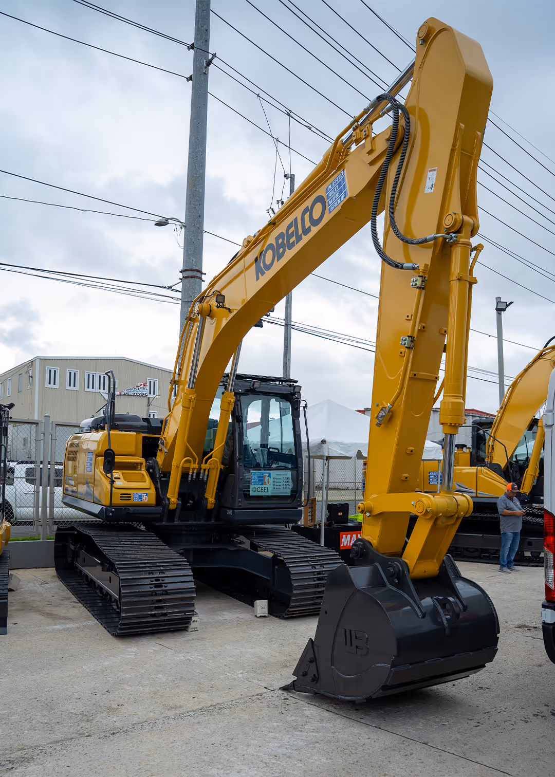 Kobelco hydraulic excavator with reinforced boom, digging bucket, and steel crawler tracks showcased at PR Wire Group in Puerto Rico, designed for precision excavation, earthmoving, and large-scale construction projects.