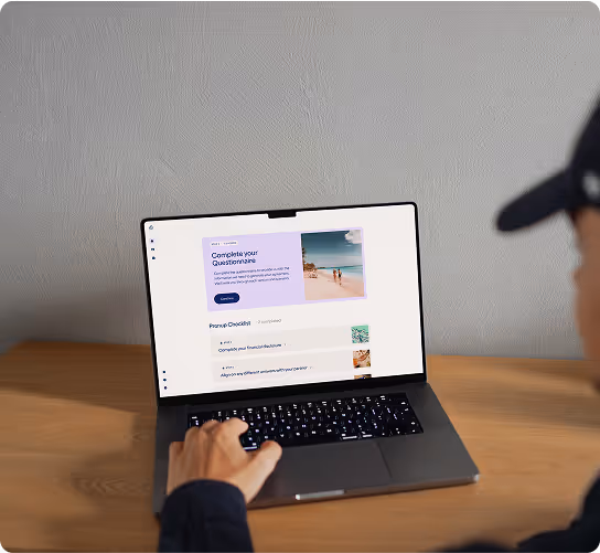 Person wearing a dark cap using a laptop on a wooden table with a webpage showing a questionnaire and travel checklist.