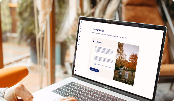 Open laptop on a desk showing a documents management webpage with text and an image of two people walking in a park with autumn foliage.