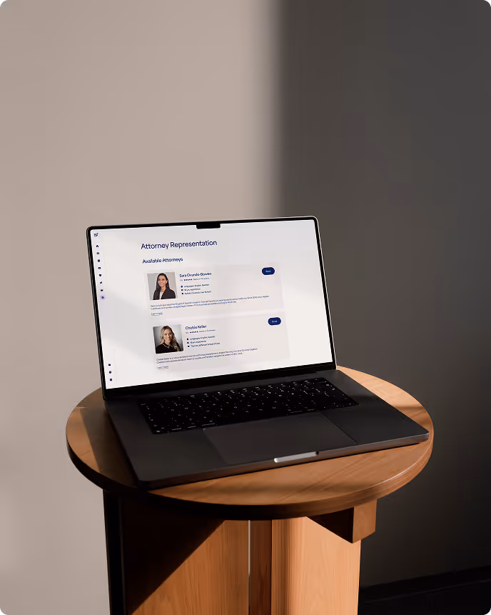 Laptop displaying a webpage titled 'Attorney Representation' with profiles of two attorneys, sitting on a round wooden table in a room with soft lighting.