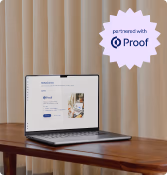 Open laptop on wooden table showing a software interface with a 'partnered with Proof' badge in the upper right corner.