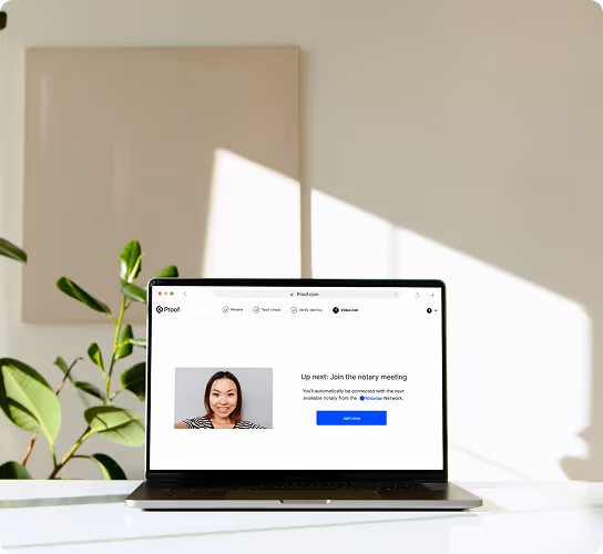 Laptop on a white table showing a video meeting screen with a woman's photo and a prompt to join the notary meeting.