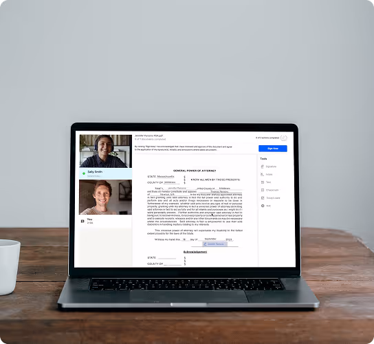 Laptop on wooden table showing a virtual meeting with two participants and a general power of attorney document on screen.
